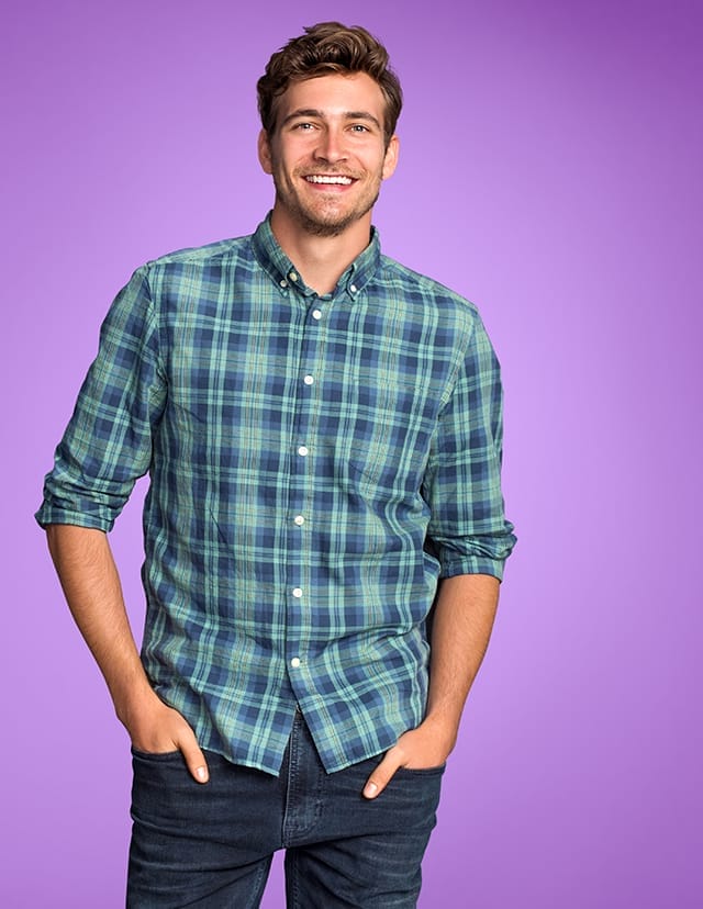 person wearing a plaid shirt smiling at the camera